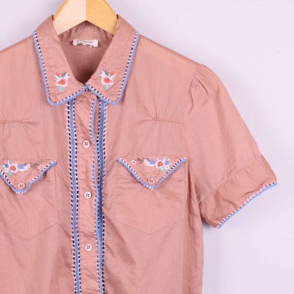 Närbild på vänster framstycke och ärm med broderi