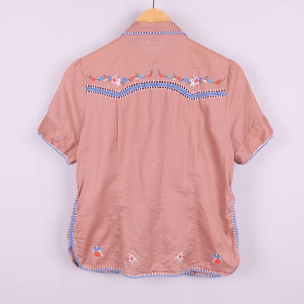 Baksidan av blus med broderade detaljer och blå kanter