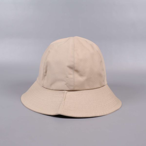 Bucket hat i beige sedd från sidan med böjt brätte