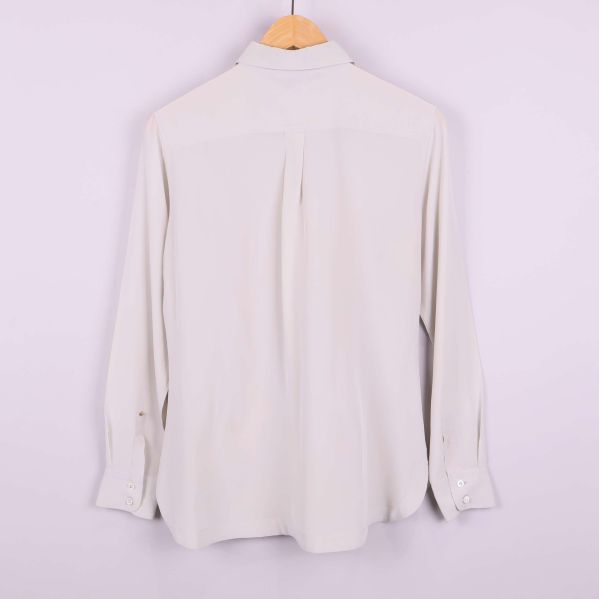 Baksida av vit långärmad blus med enkel design