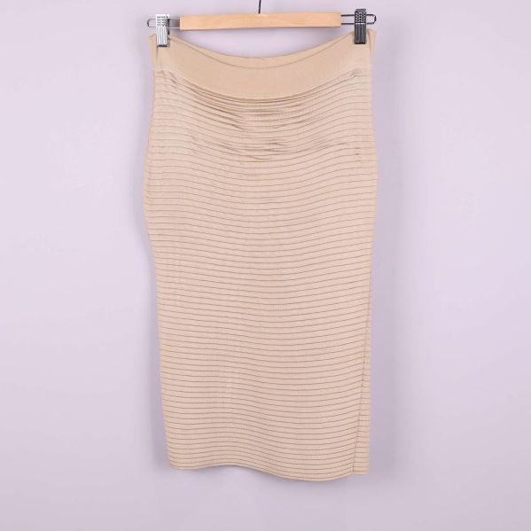 Stickad beige kjol sedd bakifrån med samma ribbade mönster