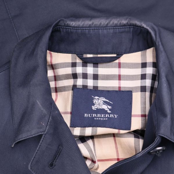 Närbild på Burberry-etikett samt klassiskt rutigt innerfoder