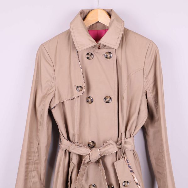 Övre del och krage på beige trenchcoat i närbild