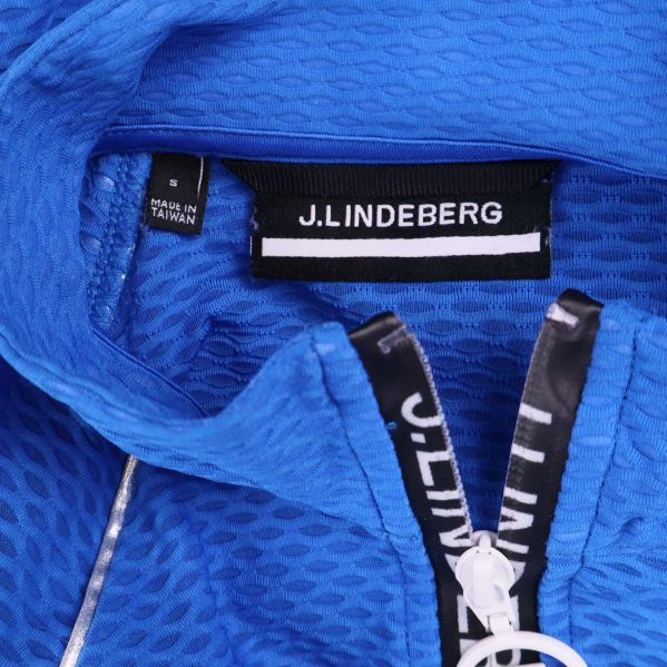 Närbild på J.Lindeberg-logotyp i kragen och dragkedja