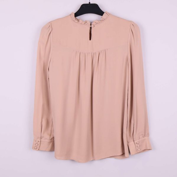 Baksidan av beige blus med knapp i nacken