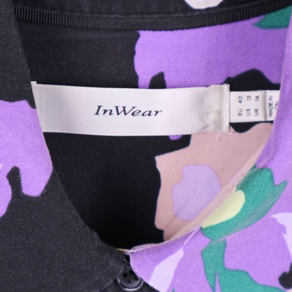 Närbild av InWear-märke i blommig blus krage
