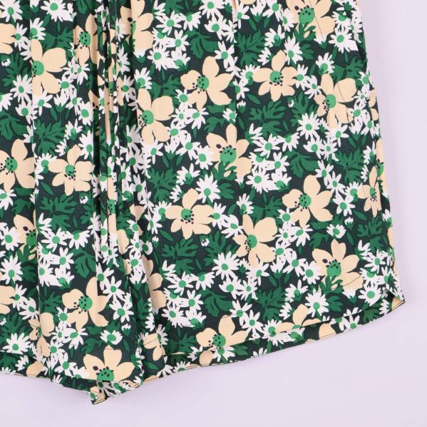 Närbild på shortsens nederkant och blommigt tyg