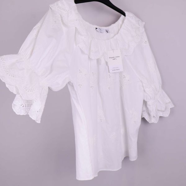 Närbild på blusens märklapp med Organic cotton info