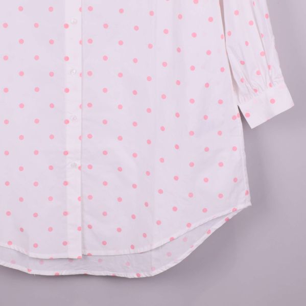 Närbild på skjortans nederkant med rosa prickar