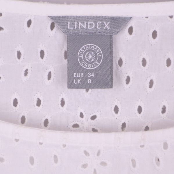 Närbild på ljust Lindex-märke och storleksetikett EUR 34