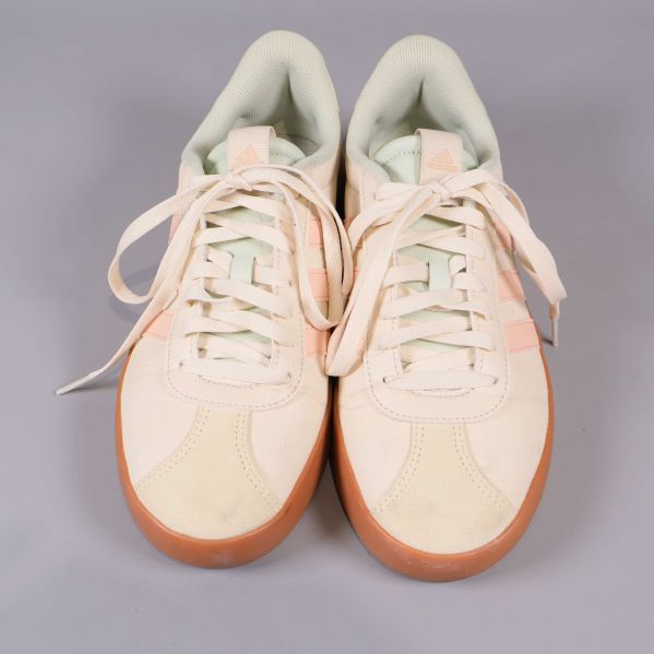 Sneakers framifrån, vitt och pastell samt snörning