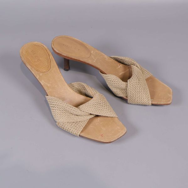 Vinklad vy på slip-in sandaler med flätad detalj