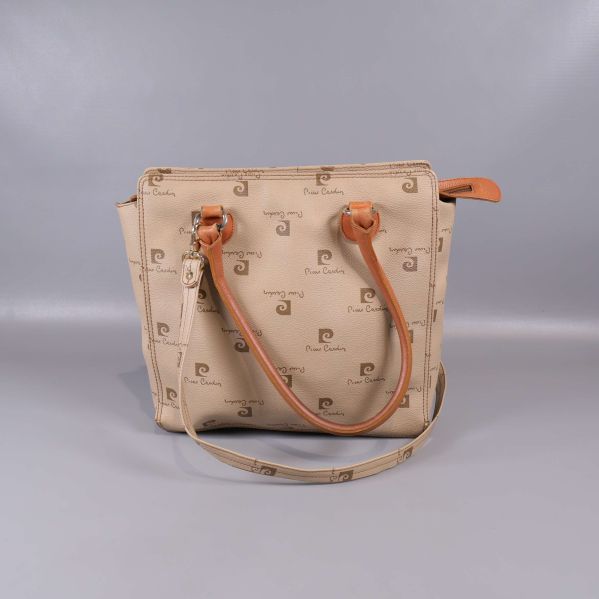 Framsida av beige Pierre Cardin väska med logomönster