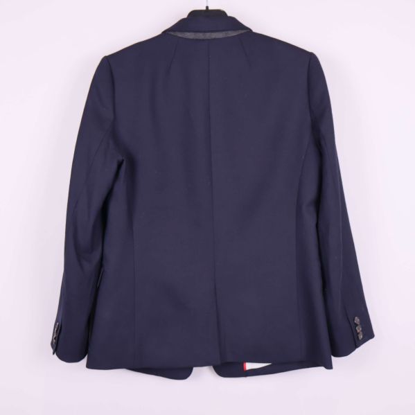 Baksidan av mörkblå blazer hängande på galge