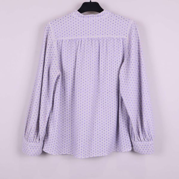 Blus med broderade blommor sedd bakifrån