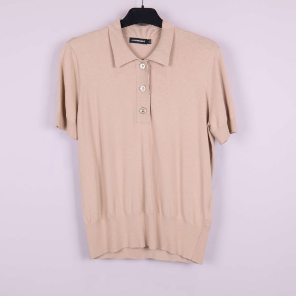 Beige kortärmad pikétröja framtill på galge