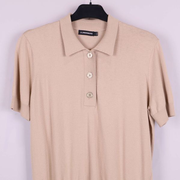 Närbild på överdelen av beige pikétröja