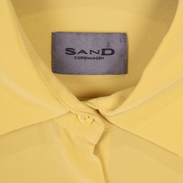 Närbild på Sand Copenhagen-märket inuti kragen