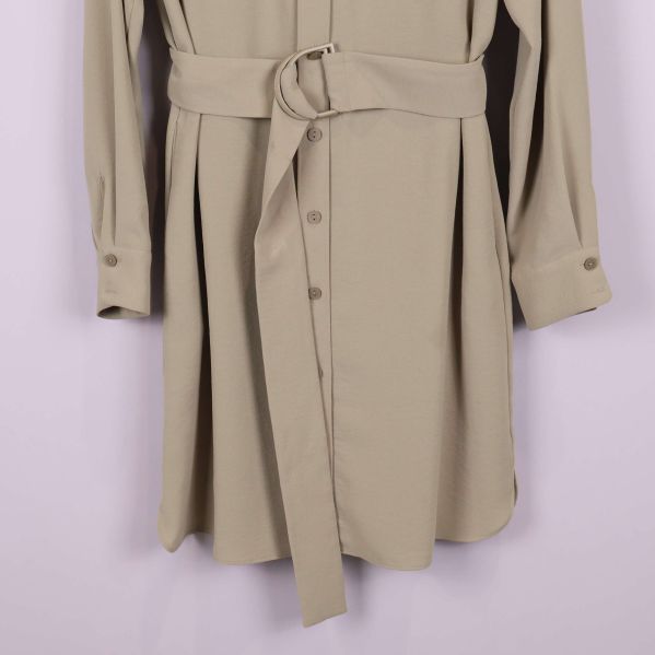Närbild på kjoldelen och bältet av den beige skjortklänningen