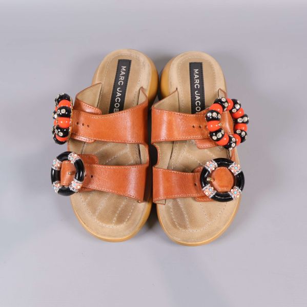 Sandaler ovanifrån med broderade och pärlade dekorationer på banden