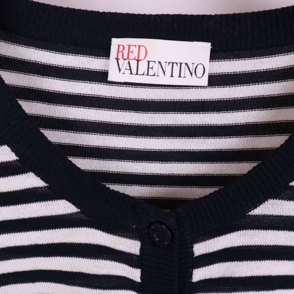 Närbild på Red Valentino-märket och mönstret vid halsen