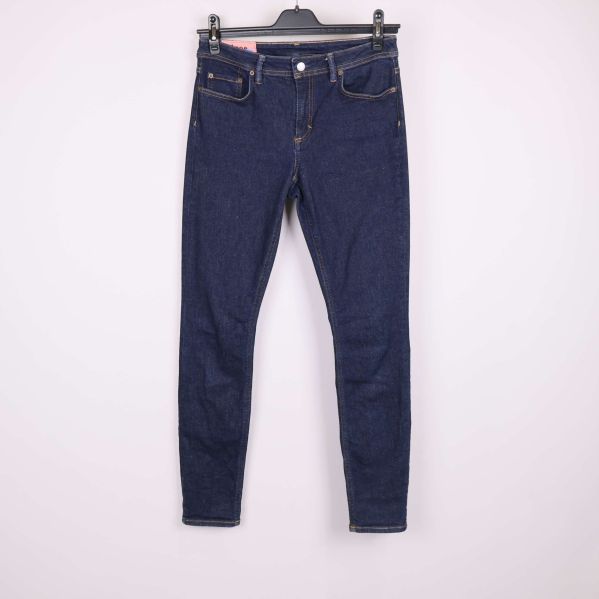 Jeans i mörkblå denim framifrån hängande på galge