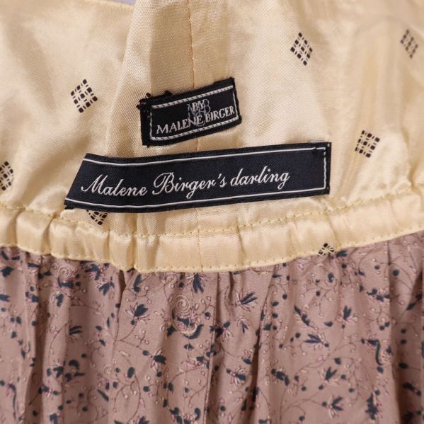 Närbild på etiketter med Malene Birger's darling-logga