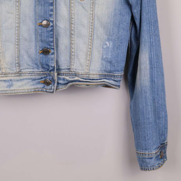 Nedre kant och ärm på jeansjacka i närbild