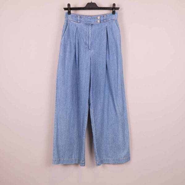Framsida av vida ljusblå jeans på galge