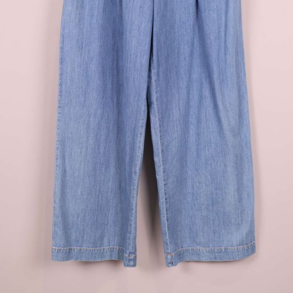 Närbild på benslut av ljusblå vida jeans