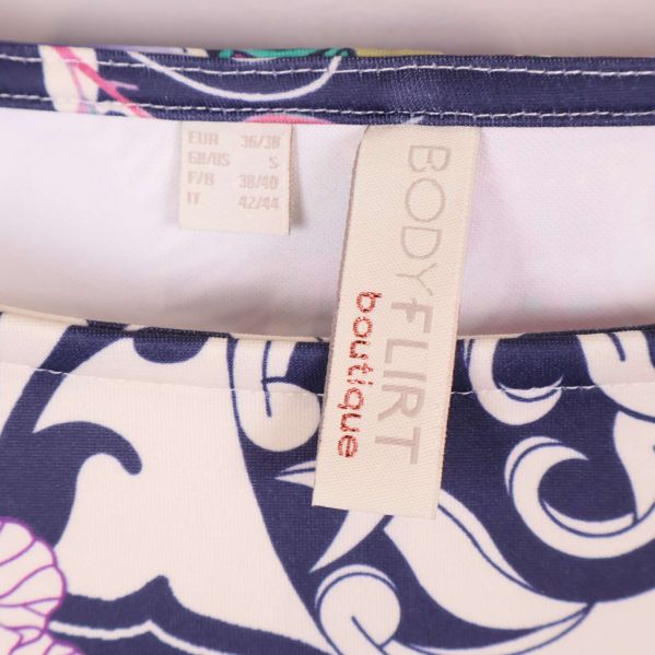 Klänningsetikett med texten BODYFLIRT boutique nära halsringning