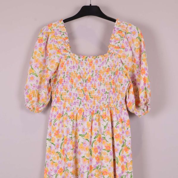Närbild på överdelen med smock och blommönster