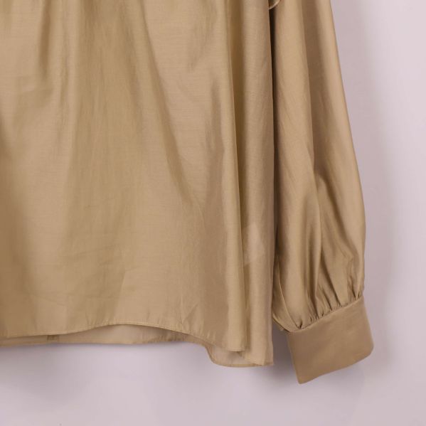 Närbild på ärm och manschett av beige blus