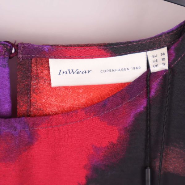 Närbild på InWear-varumärket i blusens nacke