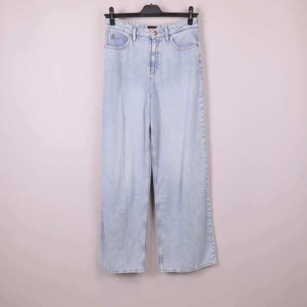 Ljusa A-linje jeans upphängda framifrån mot ljus bakgrund