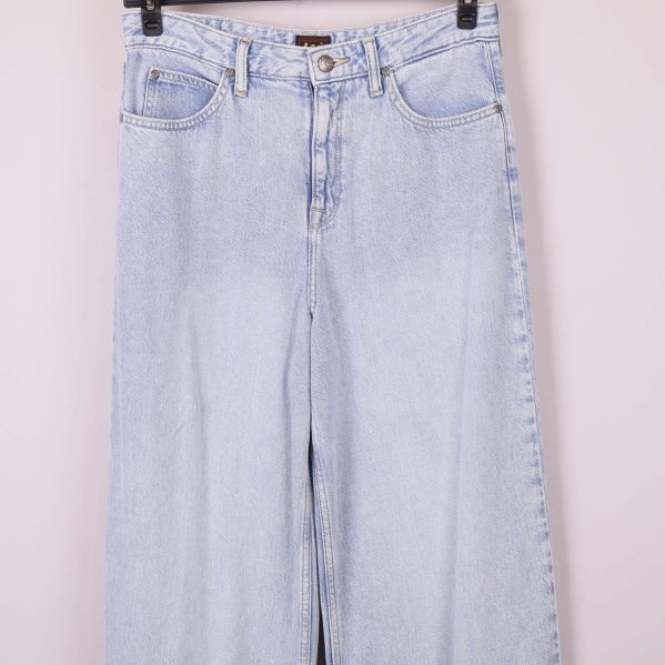 Midjeområdet och överdelen på ljusa jeans upphängda
