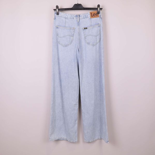 Baksidan av ljusa jeans upphängda mot ljus bakgrund