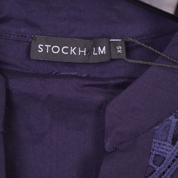 Etikett med Stockholm LM-logga på lila textil