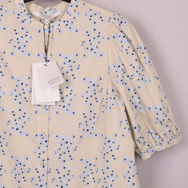 Närbild på axel och ärm av blommig blus