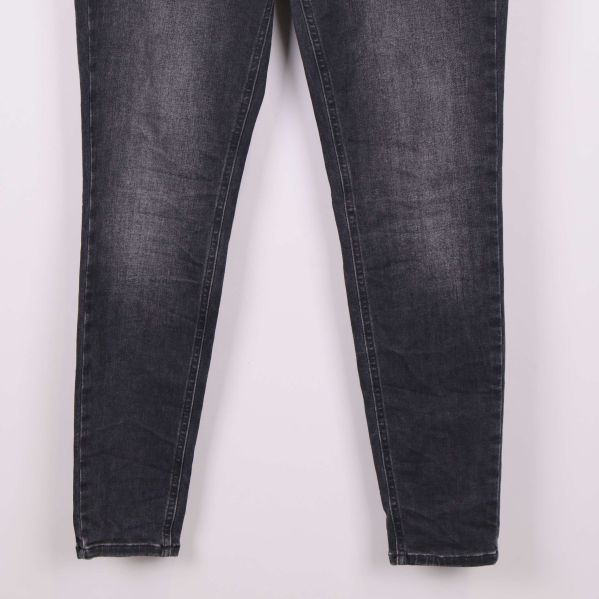 Benavslut på smala svarta jeans med lätt slitning