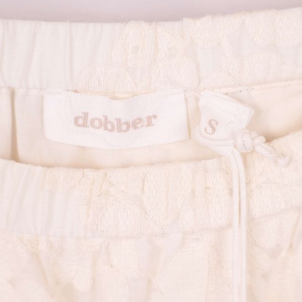 Närbild på dobber-logotyp samt resårmidja med dragsko