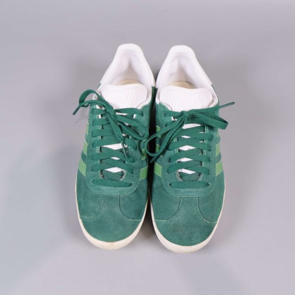 Ovanifrån av gröna sneakers med vit kant