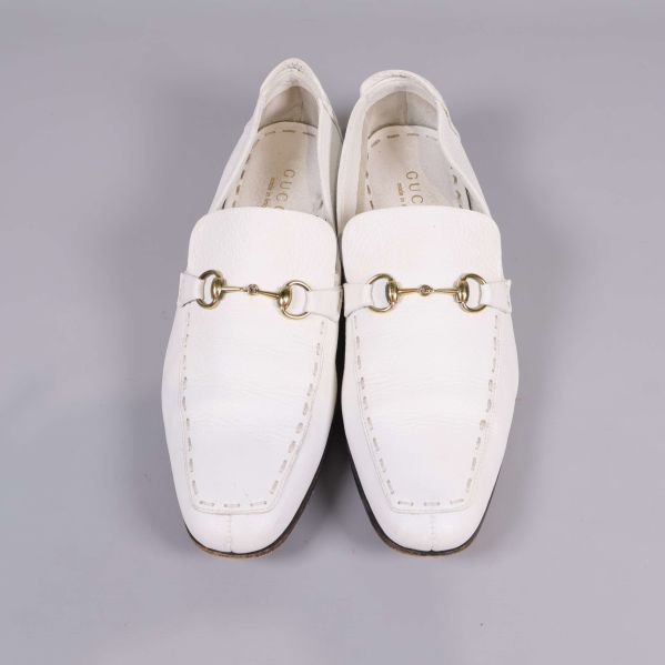 Vita loafers från Gucci fotograferade rakt framifrån