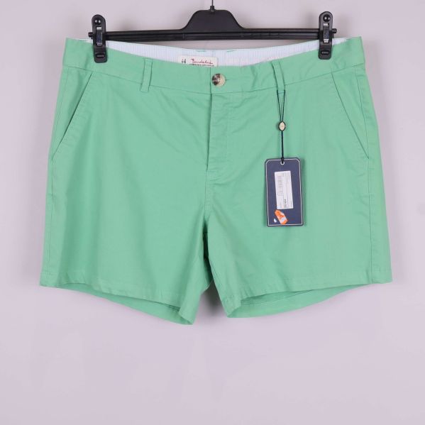 Framsida av gröna shorts med fickor och etikett