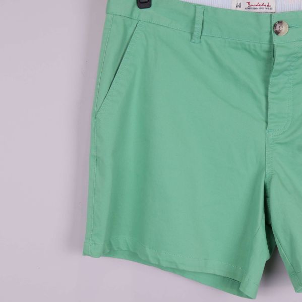 Närbild på vänster framficka och ben på gröna shorts