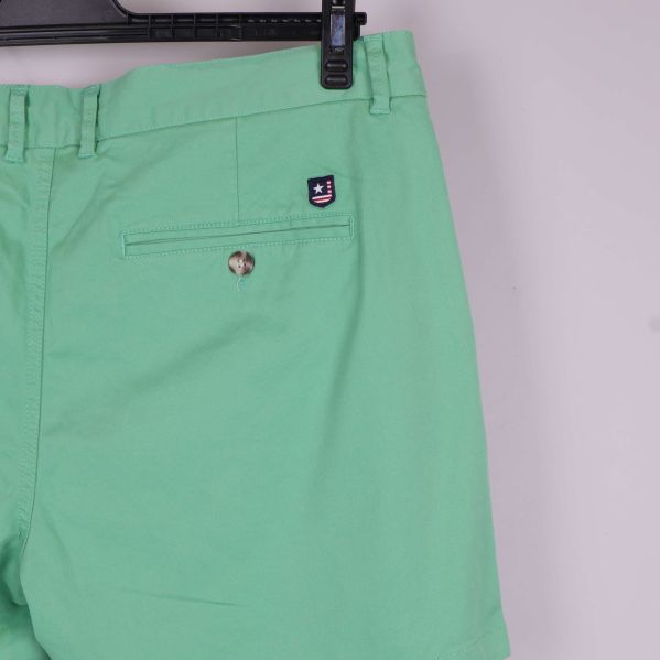 Närbild på bakficka och logga på gröna shorts