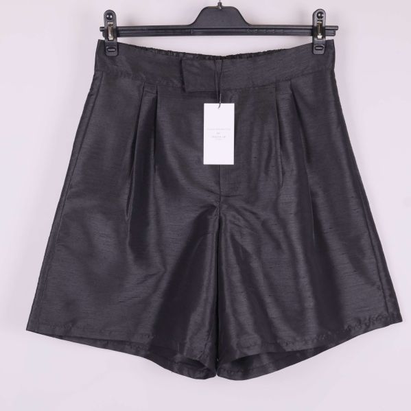 Framsida på svarta vida shorts med veck och etikett