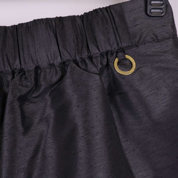 Närbild på resår och guldfärgad ring baktill på shortsen