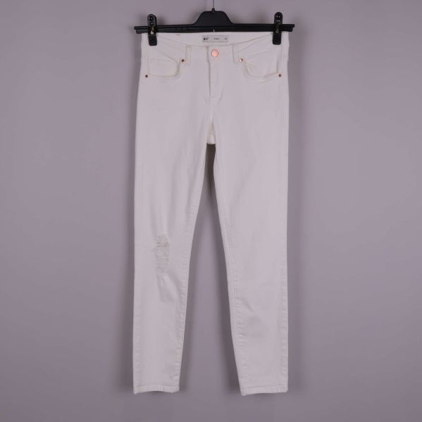 Vita slimmade jeans framifrån med slitning vid knäet