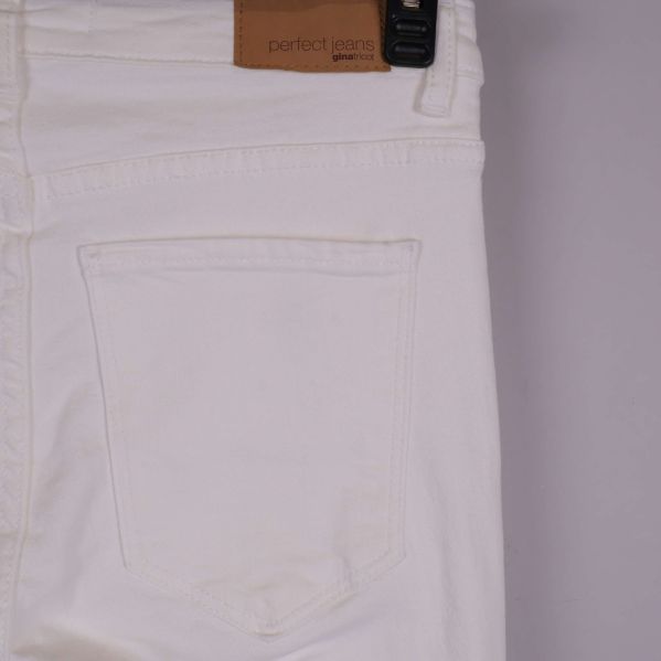 Närbild på bakficka och läderpatch på vita jeans